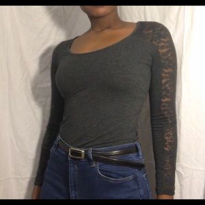 A grey long sleeve top with see through designs
